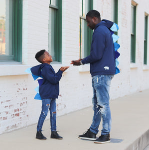 Matching blue dinosaur sweatshirts for father and son